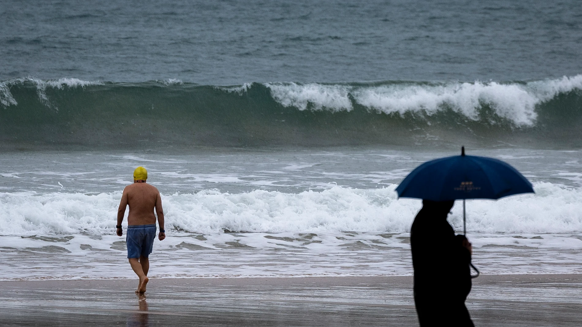 SAN SEBASTIÁN, 24/11/2025.- Un bañista se mete al agua este lunes en la playa de La Concha de San Sebastián a pesar del tiempo adverso. El tiempo previsto para hoy en Euskadi es de cielo muy nuboso o cubierto, precipitaciones débiles que a partir del mediodía aumentarán en intensidad y serán muy abundantes en la vertiente cantábrica, donde habrá también posibilidad de que caigan en forma de tormentas, y cota de nieve que podría bajar a 1.200 metros por la noche. EFE/Javier Etxezarreta