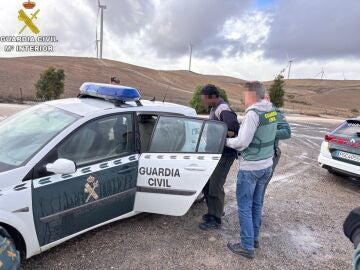 Dos agentes de la Guardia Civil trasladan al detenido