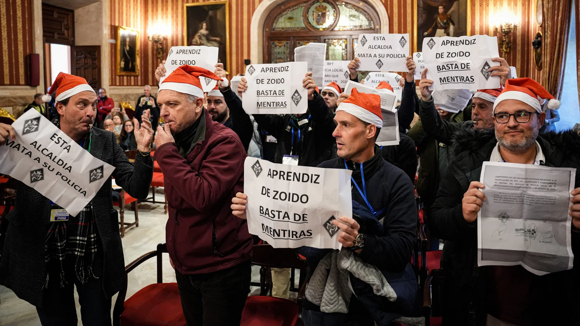 Varios policías locales protestan durante de la celebración del pleno en el Ayuntamiento de Sevilla