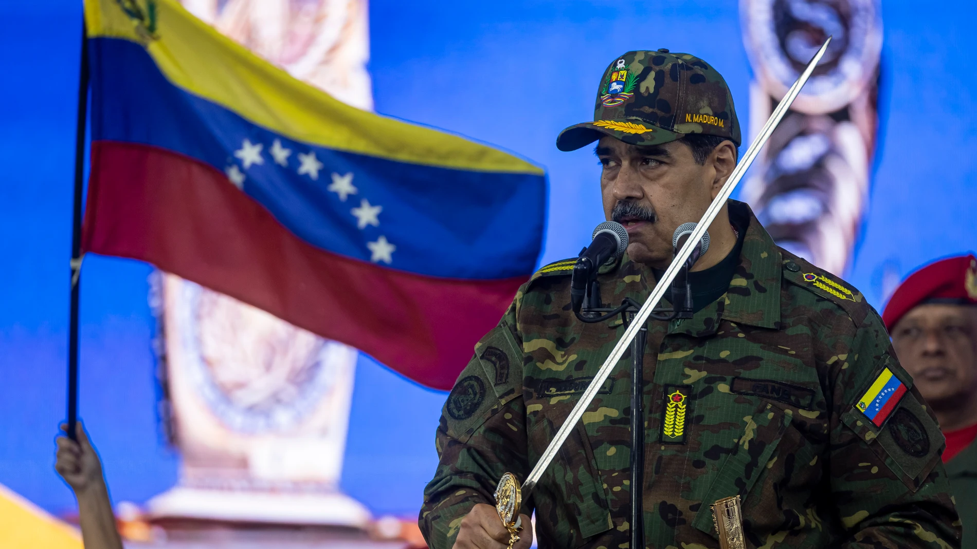 AME2673. CARACAS (VENEZUELA), 25/11/2025.- El presidente de Venezuela, Nicolás Maduro, habla sosteniendo la Espada del Perú este martes este martes, en Caracas (Venezuela). El chavismo volvió a las calles en Venezuela para reiterar su apoyo al Gobierno de Nicolás Maduro y repudiar el despliegue militar de Estados Unidos en el Caribe, que ya deja consecuencias tangibles en el país al haber provocado la cancelación en cascada de varios vuelos internacionales. EFE/ Miguel Gutiérrez