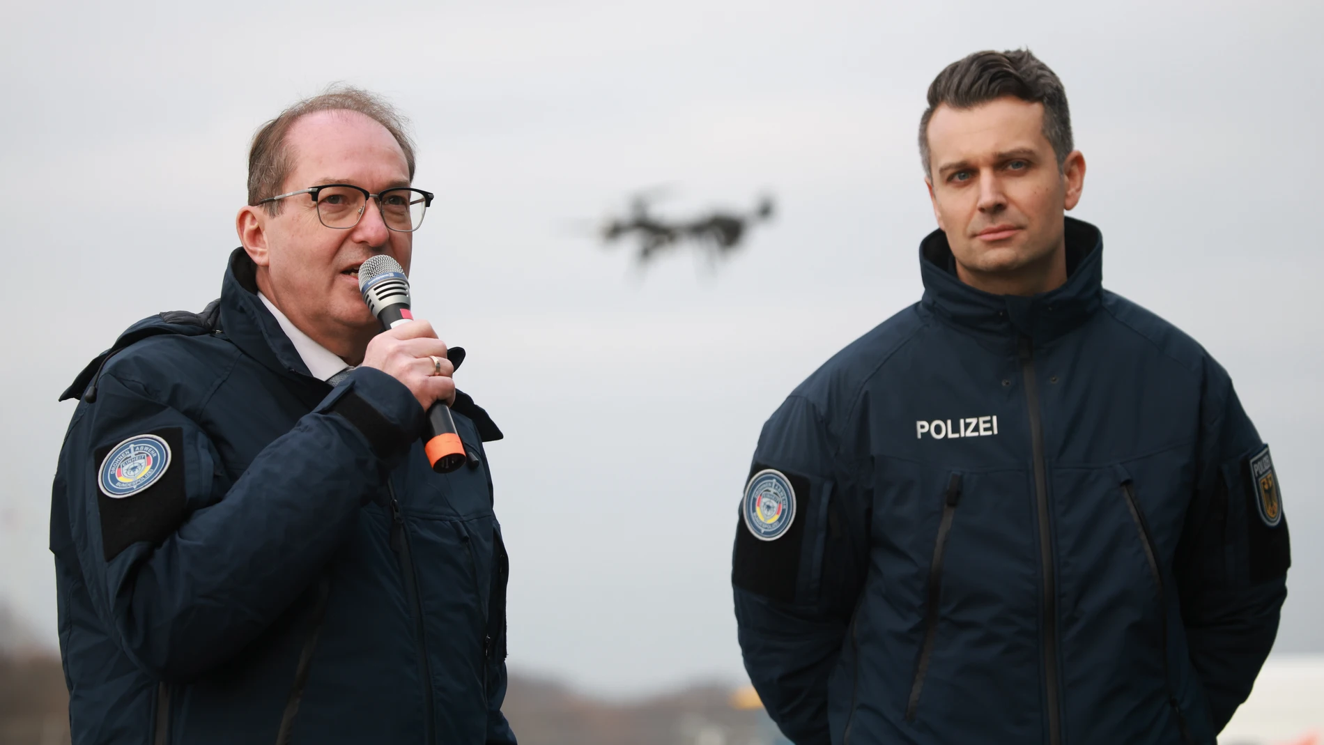 Ahrensfelde (Germany), 02/12/2025.- German Interior Minister Alexander Dobrindt (L) speaks next to Police Chief Bastian Lamers in front of a flying drone during a demonstration at the commissioning of the Federal Police drone defense unit into service in Ahrensfelde, Germany, 02 December 2025. (Alemania) EFE/EPA/CLEMENS BILAN