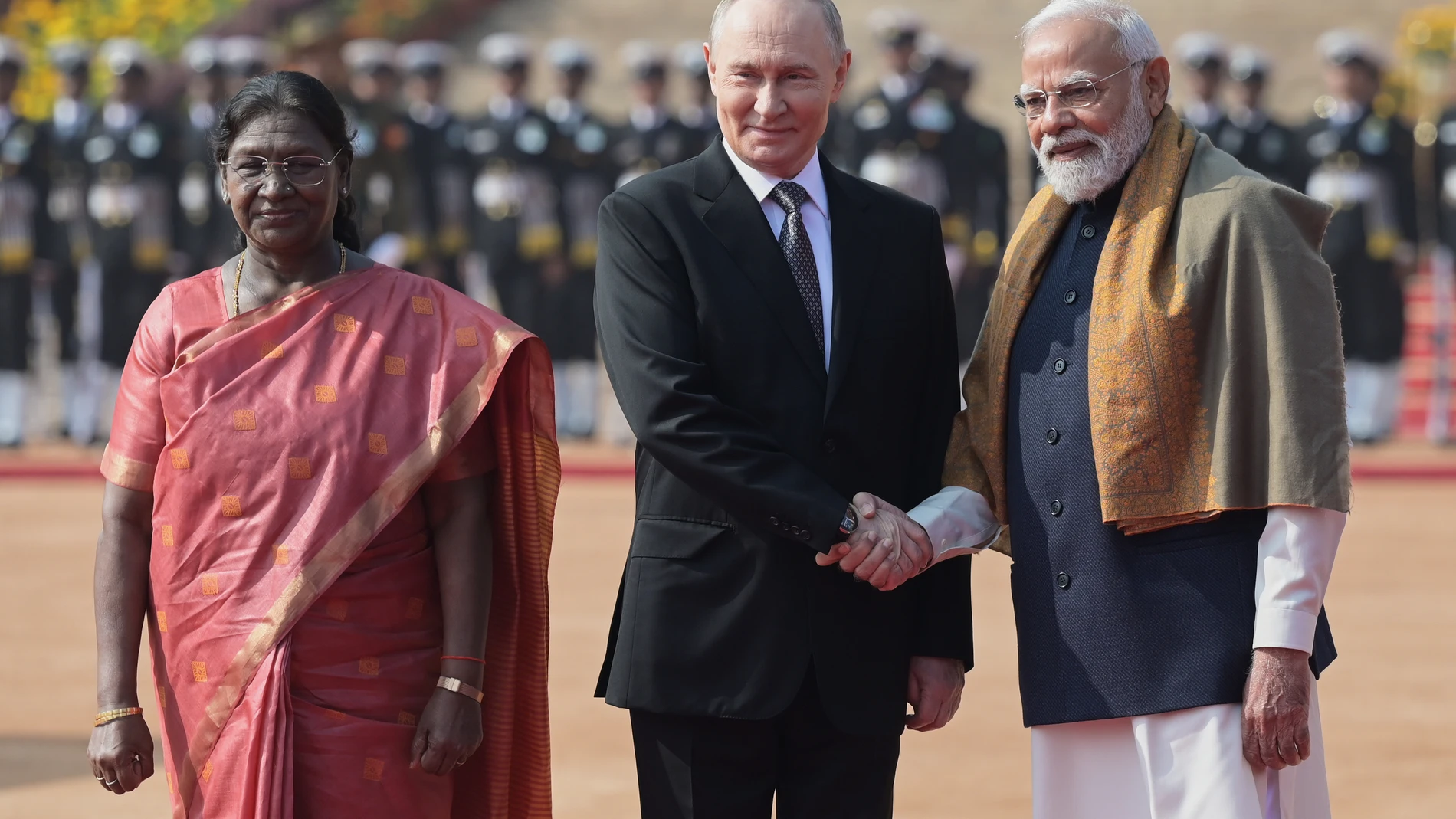 Russian President Vladimir Putin, center, shakes hands with Indian Prime Minister Narendra Modi, right, as President Droupadi Murmu looks on during a ceremonial reception at the Rashtrapati Bhavan in New Delhi, India, Friday, Dec. 5, 2025. (AP Photo)