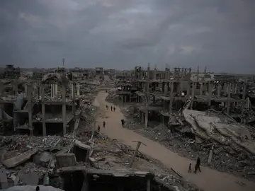 Gazatíes pasean por Jabaliya en medio de los escombros de edificios destruidos al norte de Ciudad de Gaza Palestinians walk on a street in Jabaliya, northern Gaza Strip, Saturday, Dec. 6, 2025. (AP Photo/Abdel Kareem Hana)
