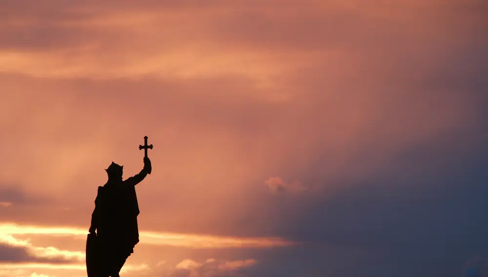 Figura silueteada por el atardecer de una escultura de Pelayo