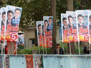 Ciudadanos hongkoneses pasan junto a carteles electorales en el distrito de Tai Po HONG KONG (China), 07/12/2025.- Citizens walk past election campaign banners in Tai Po district during the Legislative Council General Election in Hong Kong, China, 07 December 2025. Hong Kong's 'patriots-only' Legislative Council election is being held on 07 December as the city mourns the Wang Fuk Court fire in Tai Po, one of Hong Kong's deadliest fires in decades, with public calls for accountability amid a widening probe into the tragedy. (Elecciones) EFE/EPA/MAY JAMES