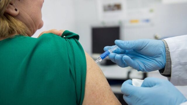 Una mujer recibe la vacuna de la gripe