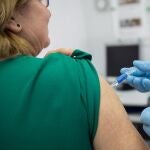 Una mujer recibe la vacuna de la gripe
