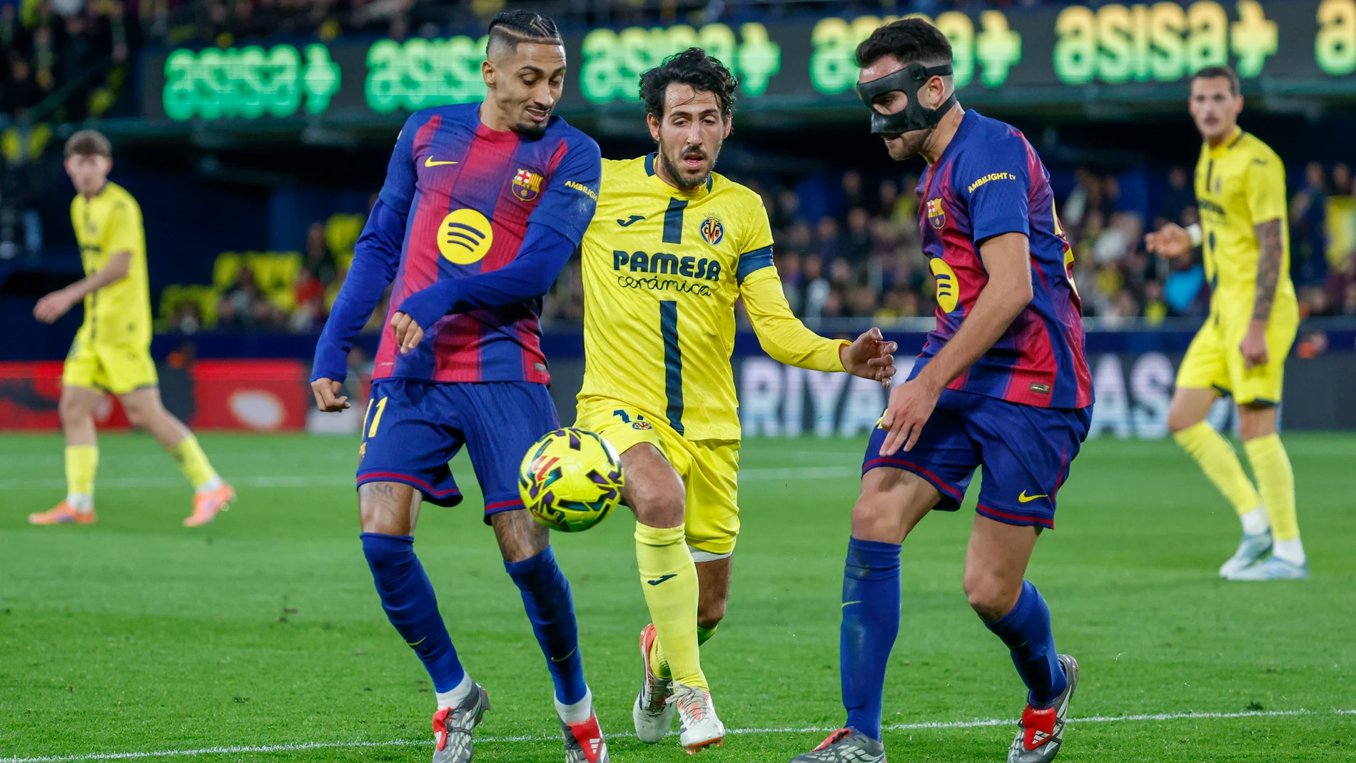 VILLARREAL (CASTELLÓN), 21/12/2025.- El centrocampista del Villarreal Dani Parejo (c) pelea un balón ante Raphinha (i) y Eric García del Barça este domingo, durante el partido de la jornada 17 de LaLiga EA Sports, que disputan Villarreal CF y el FC Barcelona en el Estadio de la Cerámica. EFE/ Ana Escobar