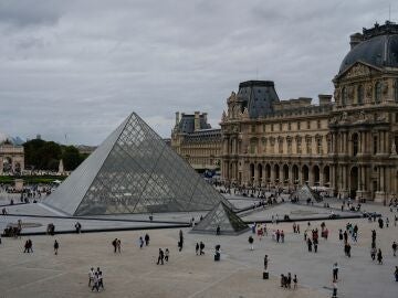 FILE - People walk outside the Louvre museum, Sunday, Aug. 31, 2025, in Paris. 