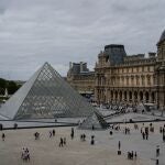 FILE - People walk outside the Louvre museum, Sunday, Aug. 31, 2025, in Paris. 