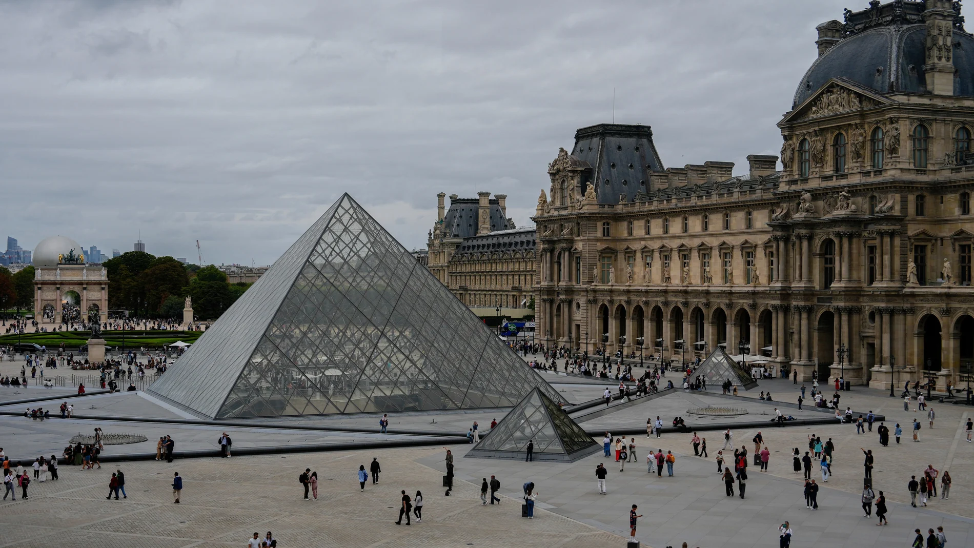 FILE - People walk outside the Louvre museum, Sunday, Aug. 31, 2025, in Paris.