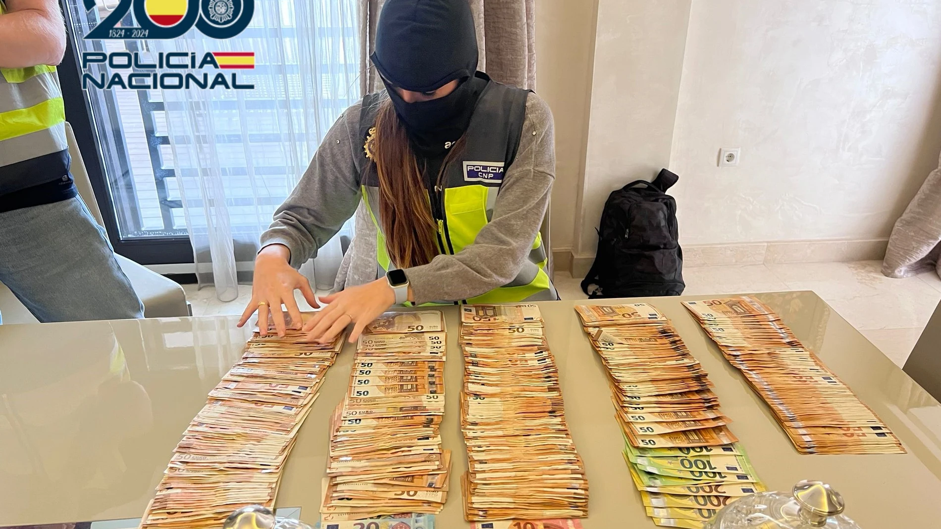 Un agente de la Policía Nacional cuenta billetes en una operación