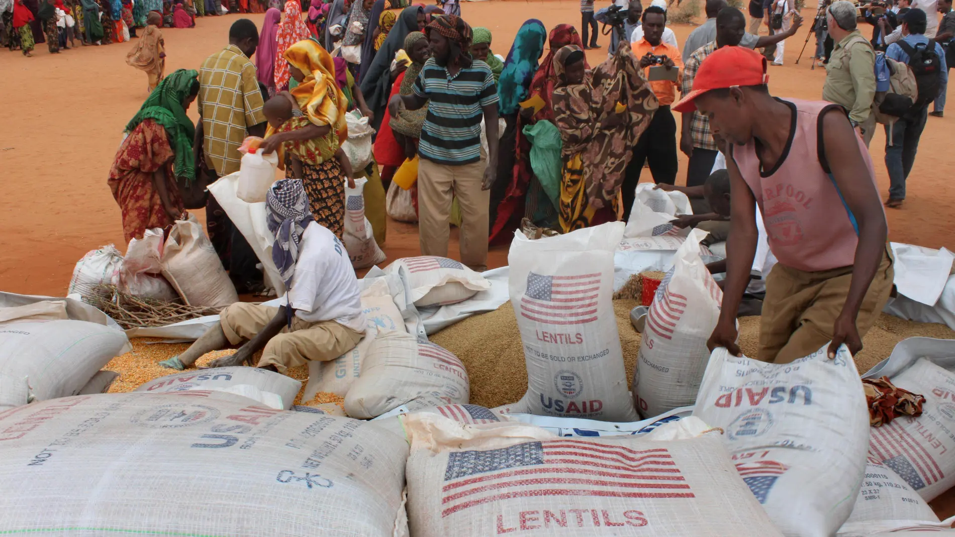 FILE - Workers distribute food aid from the World Food Program at a refugee camp in Dolo, Somalia on July 18. 2012. (AP Photo/Jason Straziuso, file)