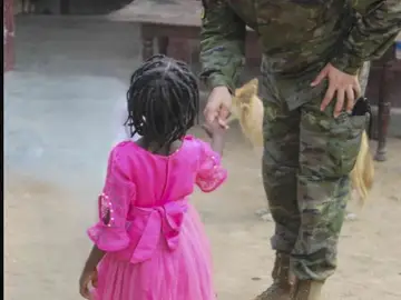 Un militar entrega un regalo a un niño en el orfanato Un militar entrega un regalo a un niño en el orfanato