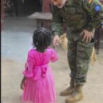 Un militar entrega un regalo a un ni&ntilde;o en el orfanato