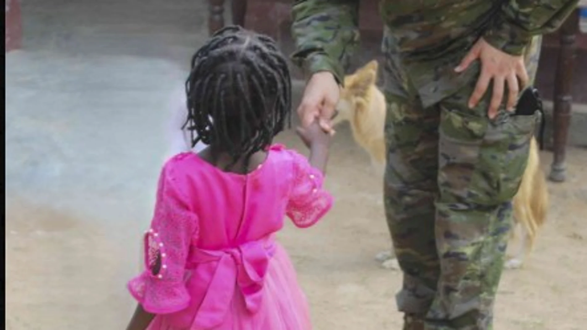 Un militar entrega un regalo a un niño en el orfanato