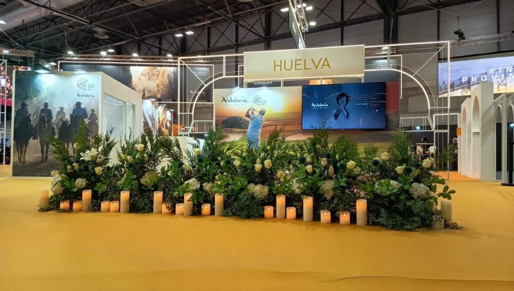 Stand de Huelva en Fitur, con flores y velas en recuerdo de las víctimas de la tragedia ferroviaria de Adamuz