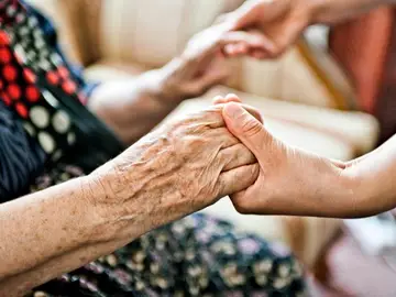 Una trabajadora ayudando a una anciana. Una trabajadora ayudando a una anciana.