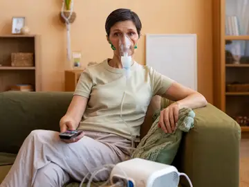 Una paciente con EPOC durante su rutina diaria Paciente con EPOC utilizando un dispositivo respiratorio en su vida diaria para aliviar la dificultad respiratoria