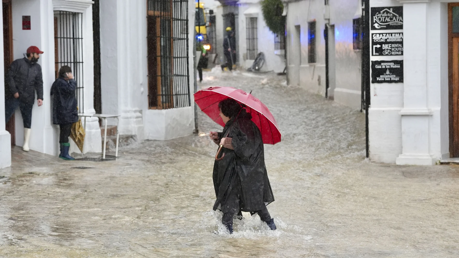 Una vecina de Grazalema (Cádiz) camina por una calle inundada debido a las intensas lluvias que se registran este miércoles en la localidad gaditana, que acumula 238,3 litros por metro cuadrado y que suceden al mes de enero más lluvioso desde principios del siglo XX en la localidad.