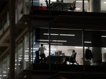 Trabajadores hasta tarde en sus oficinas Trabajadores hasta tarde en sus oficinas