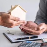 Imagen de archivo de una persona don&aacute;ndole su vivienda a otra