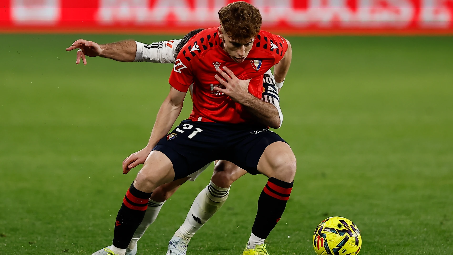 PAMPLONA, 21/02/2026.- El centrocampista de Osasuna Víctor Muñoz (delante) lucha con Dani Carvajal, del Real Madrid, durante el partido de la jornada 25 de LaLiga que disputan CA Osasuna y Real Madrid, este sábado en el estadio de El Sadar de Pamplona. EFE/Villar López