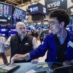 Specialists Meric Greenbaum, left, and Alex Weitzman work on the floor of the New York Stock Exchange, Friday, Feb. 20, 2026. 