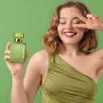 Modelo sosteniendo un frasco de perfume verde