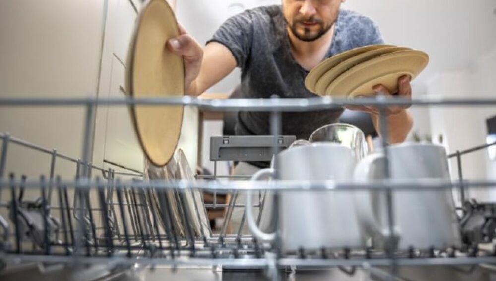 Hombre colocando los platos sucios en el lavavajillas