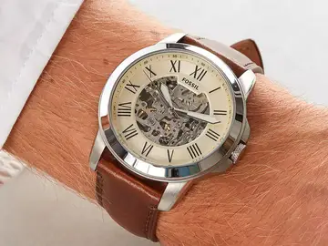 Su esfera abierta deja ver parte del movimiento automático del reloj Fossil Grant