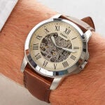 Su esfera abierta deja ver parte del movimiento autom&aacute;tico del reloj