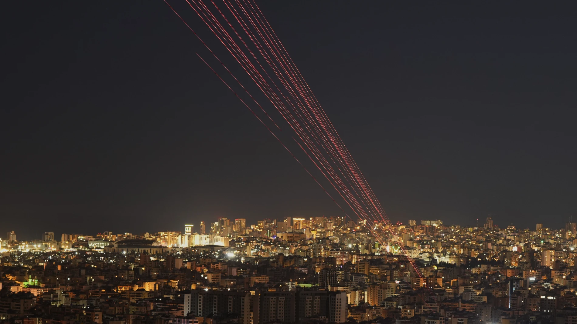 Tracer rounds light the sky as people fire live rounds into the air during a televised speech by Hezbollah leader Naim Kassem in Dahiyeh, Beirut's southern suburbs, Lebanon, Wednesday, March 4, 2026. (AP Photo/Hassan Ammar)