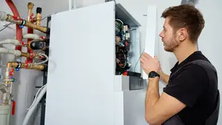 Imagen de archivo de un fontanero tratando una caldera Imagen de archivo de un fontanero tratando una caldera
