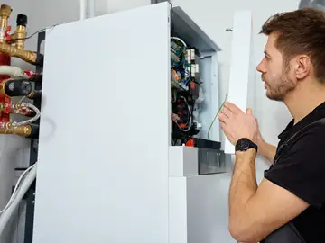 Imagen de archivo de un fontanero tratando una caldera Imagen de archivo de un fontanero tratando una caldera