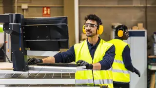 Imagen de archivo de un trabajador junto a un ordenador Imagen de archivo de un trabajador junto a un ordenador