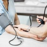 Enfermera midiendo la presi&oacute;n arterial de una paciente de edad avanzad