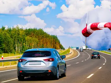 Imagen de archivo de varios vehículos circulando por una carretera con mucho viento Imagen de archivo de varios vehículos circulando por una carretera con mucho viento