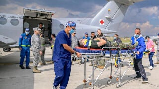 AME6865. BOGOT&Aacute; (COLOMBIA), 23/03/2026.- Fotograf&iacute;a cedida por las Fuerzas Militares de Colombia (FF.MM.) que muestra a integrantes de organismos de rescate trasladando un herido de un accidente a&eacute;reo este lunes, en el Comando A&eacute;reo de Transporte Militar (CATAM)en Bogot&aacute; (Colombia). El accidente de un avi&oacute;n H&eacute;rcules C-130 de la Fuerza Aeroespacial Colombiana (FAC), que cay&oacute; a tierra tras despegar con 125 personas a bordo de la ciudad amaz&oacute;nica de Puerto Legu&iacute;zamo, en el departamento del Putum...