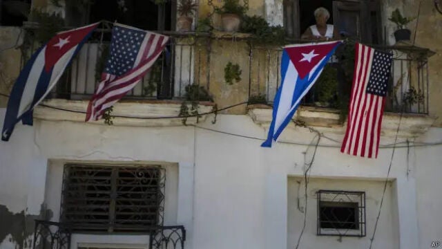 Una se&ntilde;ora cubana luce en el balc&oacute;n la bandera de su pa&iacute;s junto a la de los Estados Unidos de Am&eacute;rica