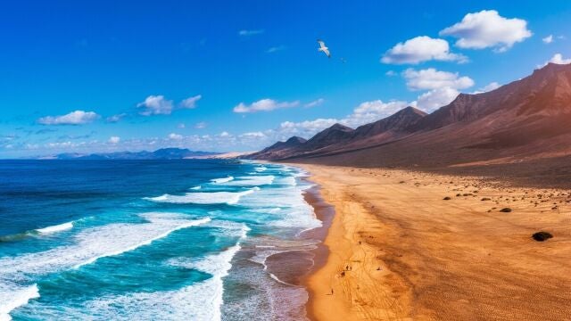 Paisaje costero de las Islas Canarias con playa y monta&ntilde;as volc&aacute;nicas