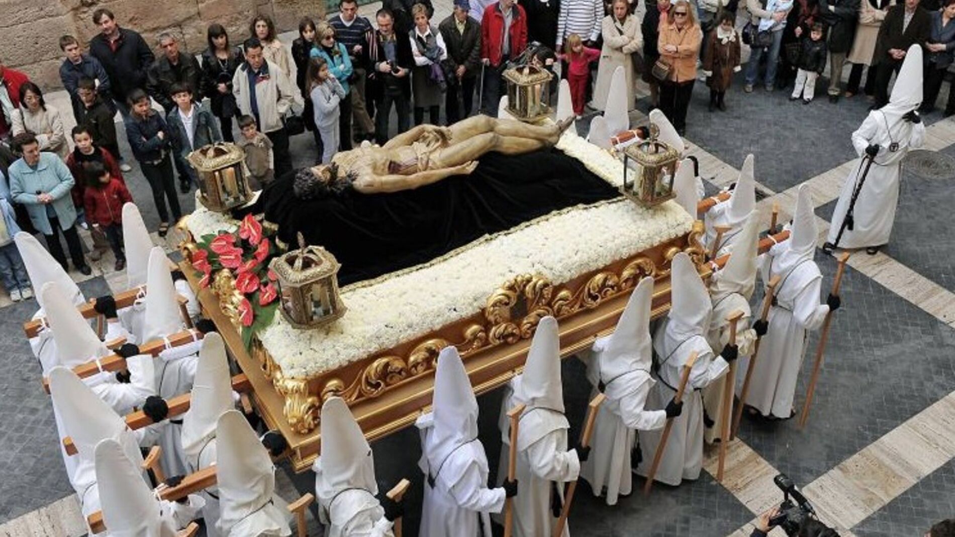Los nazarenos se visten de blanco en señal de luto en la procesión de este Sábado Santo en Murcia