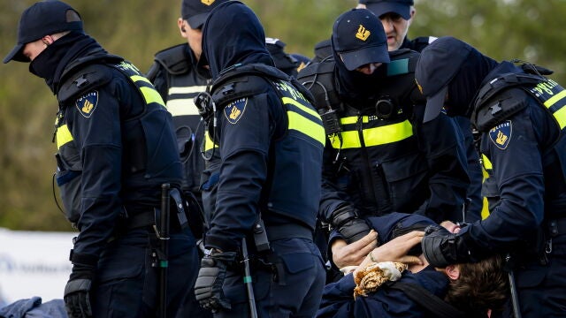 Elst (Netherlands), 10/04/2026.- Police officers from a mobile unit detain activists from the Geef Tegengas collective blocking the Betuwe Route, a freight-only railway, near Elst, the Netherlands, 10 April 2026. The activists halted all freight traffic on this artery connecting the Port of Rotterdam to Germany to protest human rights violations worldwide and the climate crisis. (Protestas, Alemania, Pa&iacute;ses Bajos; Holanda) EFE/EPA/SEM VAN DER WAL