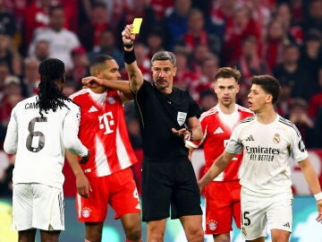 MUNICH (Germany), 15/04/2026.- Referee Slavko Vincic (C) shows yellow card to Eduardo Camavinga (L) of Real Madrid during the UEFA Champions League quarter-finals, 2nd leg match FC Bayern Munich against Real Madrid, in Munich, Germany, 15 April 2026. (Liga de Campeones, Alemania) EFE/EPA/ANNA SZILAGYI