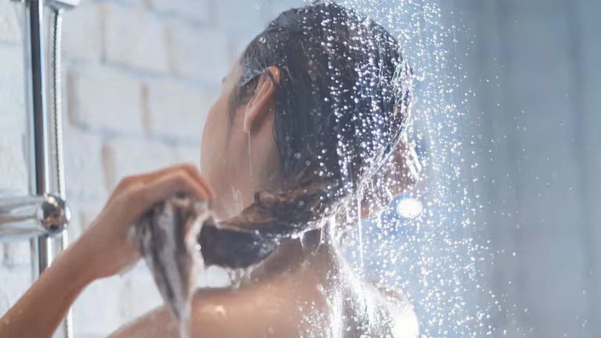 Mujer lavándose el cabello bajo la ducha