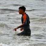 Un migrante marroqu&iacute; camina al llegar a la orilla de la playa del Tarajal en Ceuta