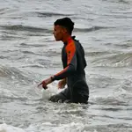 Un migrante marroquí camina al llegar a la orilla de la playa del Tarajal en Ceuta