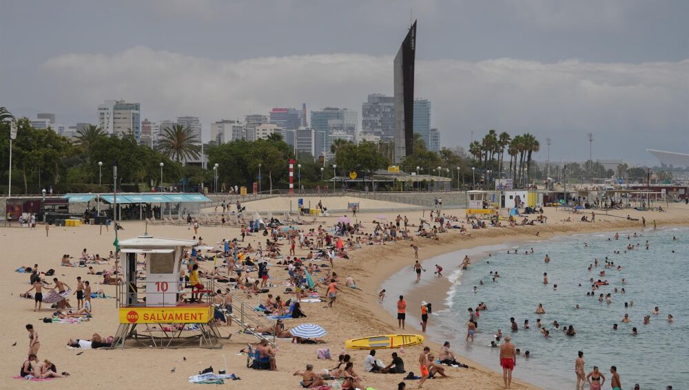 Bañistas toman el sol y se bañan en las playas de Barcelona