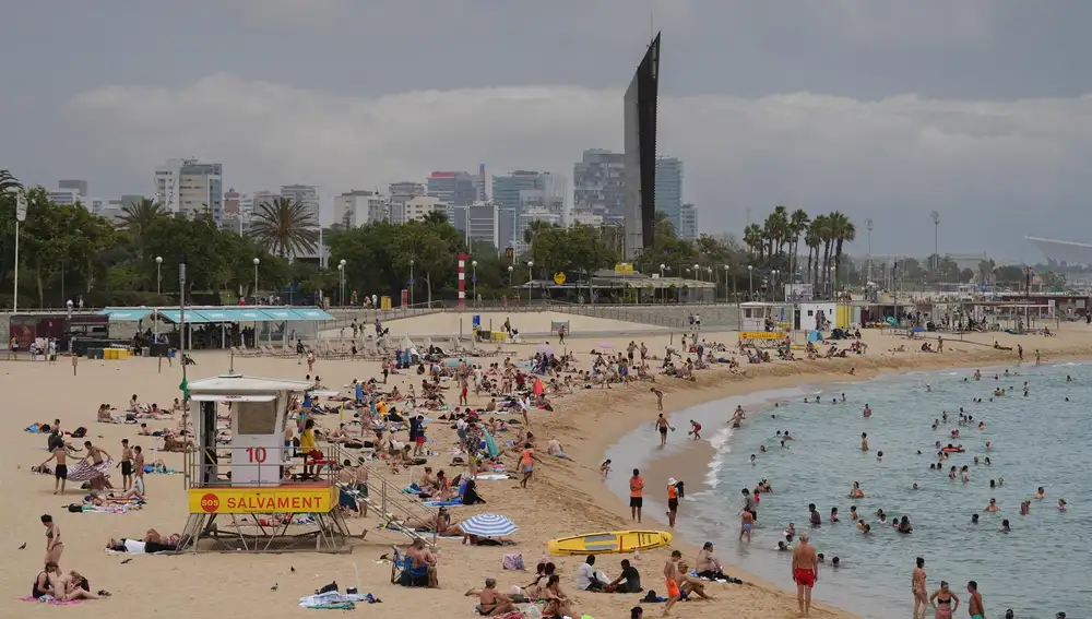 Bañistas toman el sol y se bañan en las playas de Barcelona