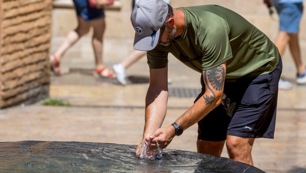 MÁLAGA, 04/08/2026.- Un hombre se refresca en el centro histórico de Málaga este mediodía. Las altas temperaturas previstas para hoy han motivado la activación de avisos en ocho comunidades autónomas ante la previsión de que los termómetros ronden los 40 grados en muchos lugares, según los datos de